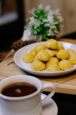 معمول العيد الطازج محشو بالتمر ومزين بالسكر البودرة بعد الخبز