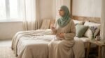 أول علامات تلقيح البويضة: امرأة محجبة تضع يدها على بطنها وتشرب الماء